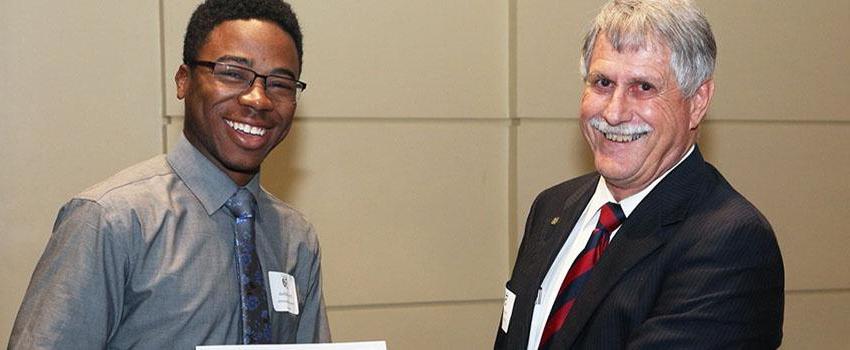 Dr. Steadman shaking hands with an engineering scholarship recipient.