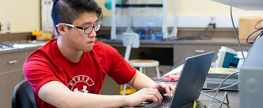 Male student working at computer in Engineering lab.